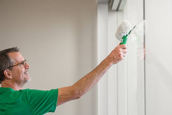 janitor cleaning office window from inside