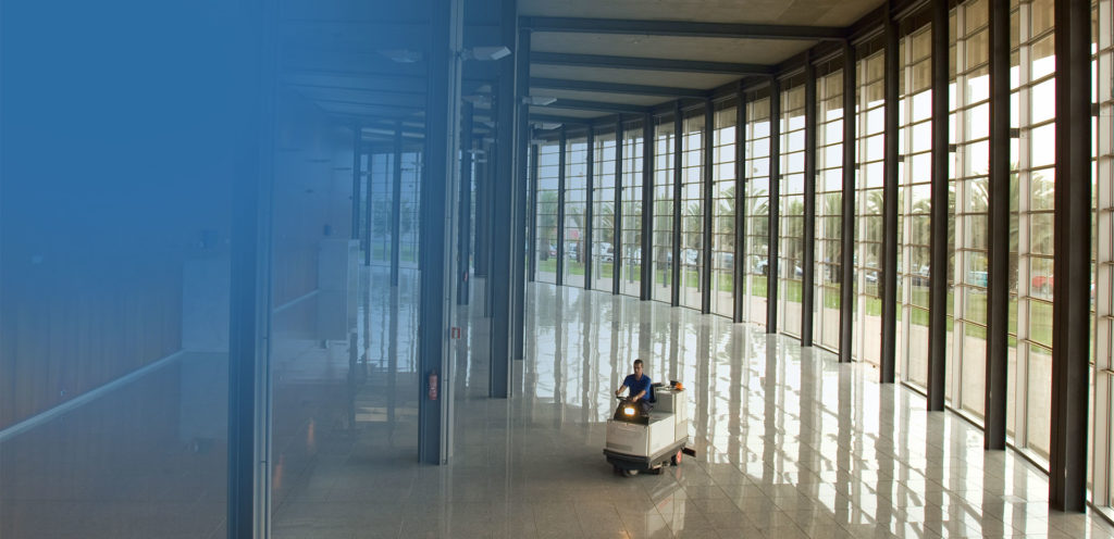 Employee on industrial floor cleaner