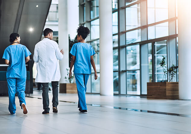 Medical professionals walking through a clean hospital lobby