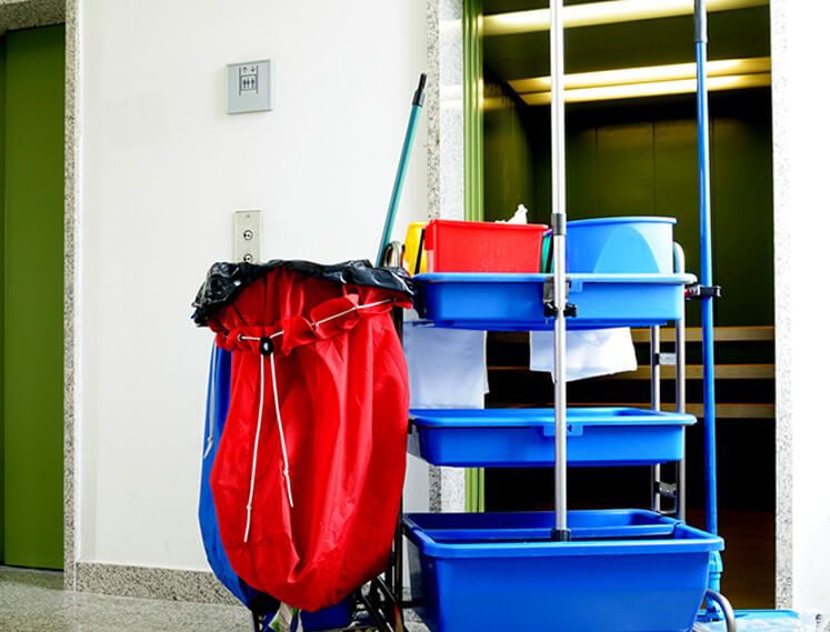 A professional cleaner cart with the top level full of cleaning consumables