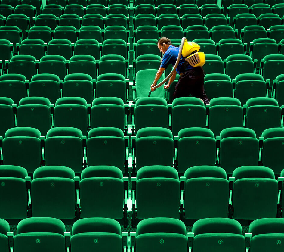 Commercial cleaning professional vacuuming auditorium seating