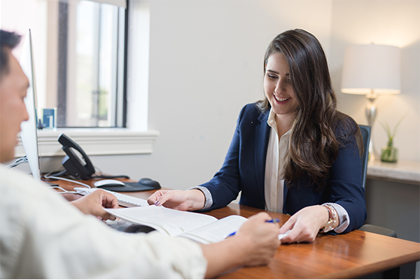 Happy business owner reviewing documents with clients in clean office