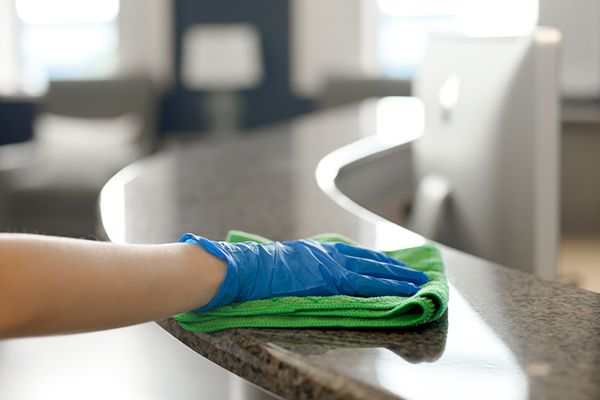commercial cleaning professional wiping office front counter