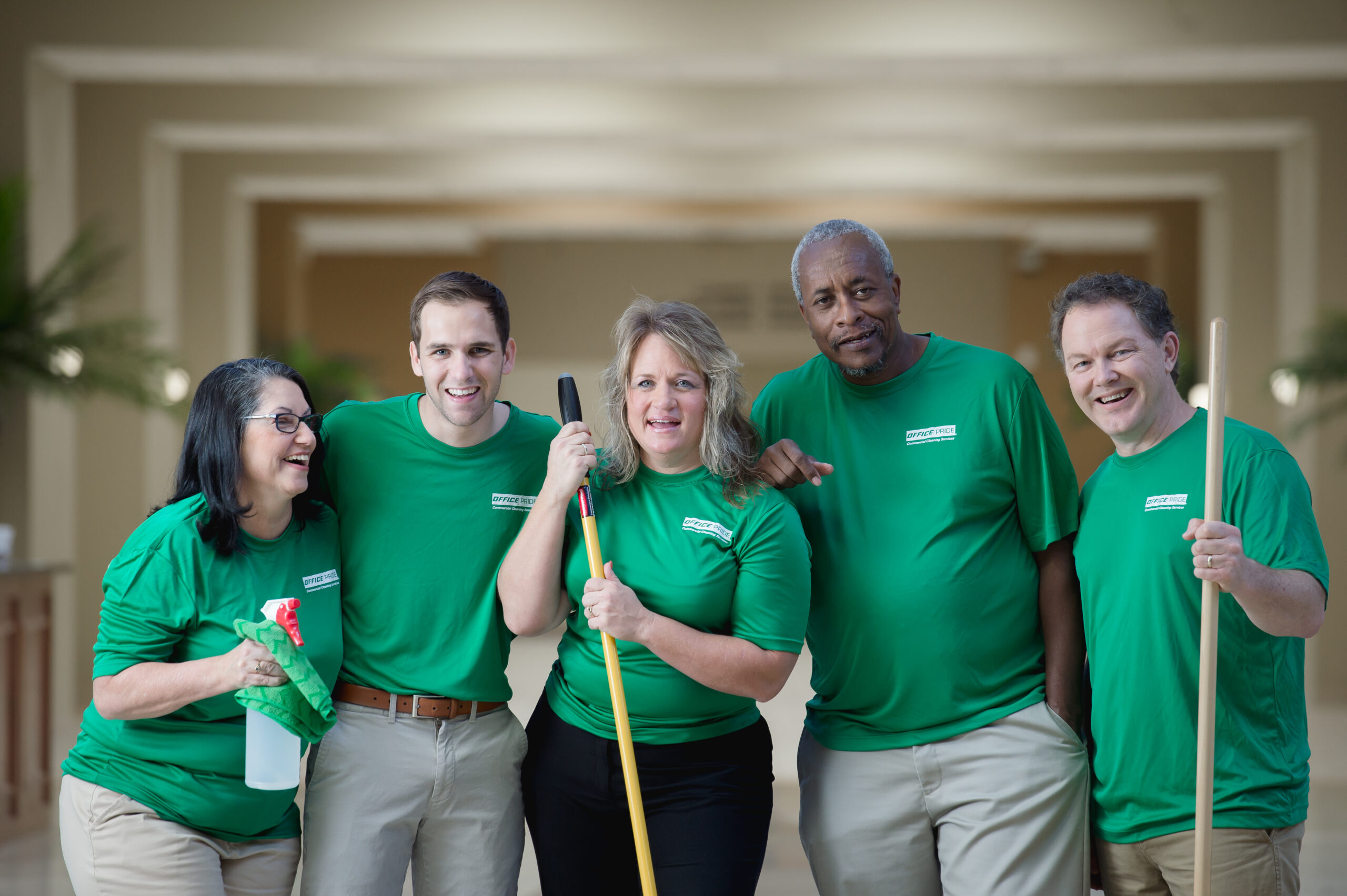 Commercial cleaning professional team group picture holding cleaning accessories