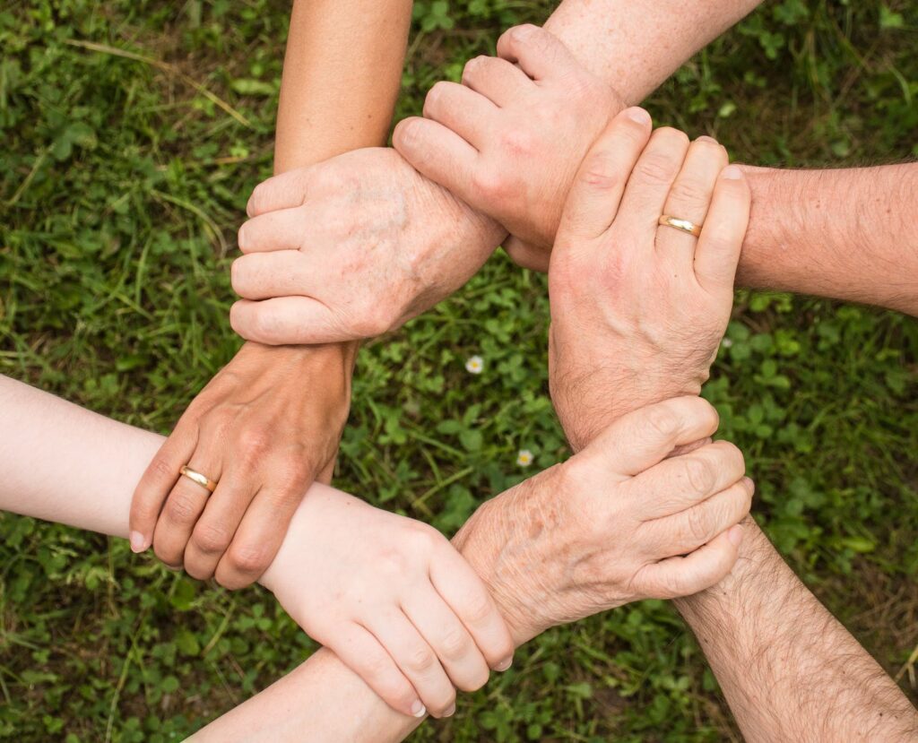 teamwork symbolism by group of hand holding each other
