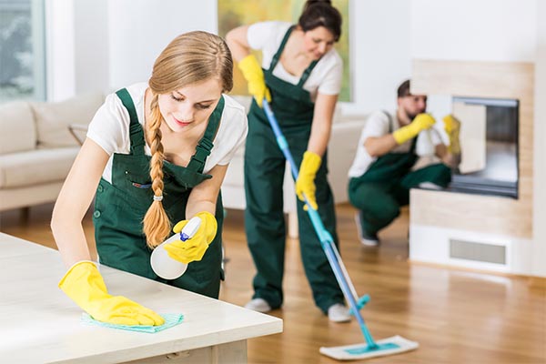 commercial cleaning team cleaning separate parts of a room