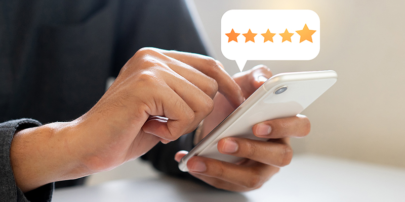 graphic of a hands holding a phone with a star rating inside a text bubble above it