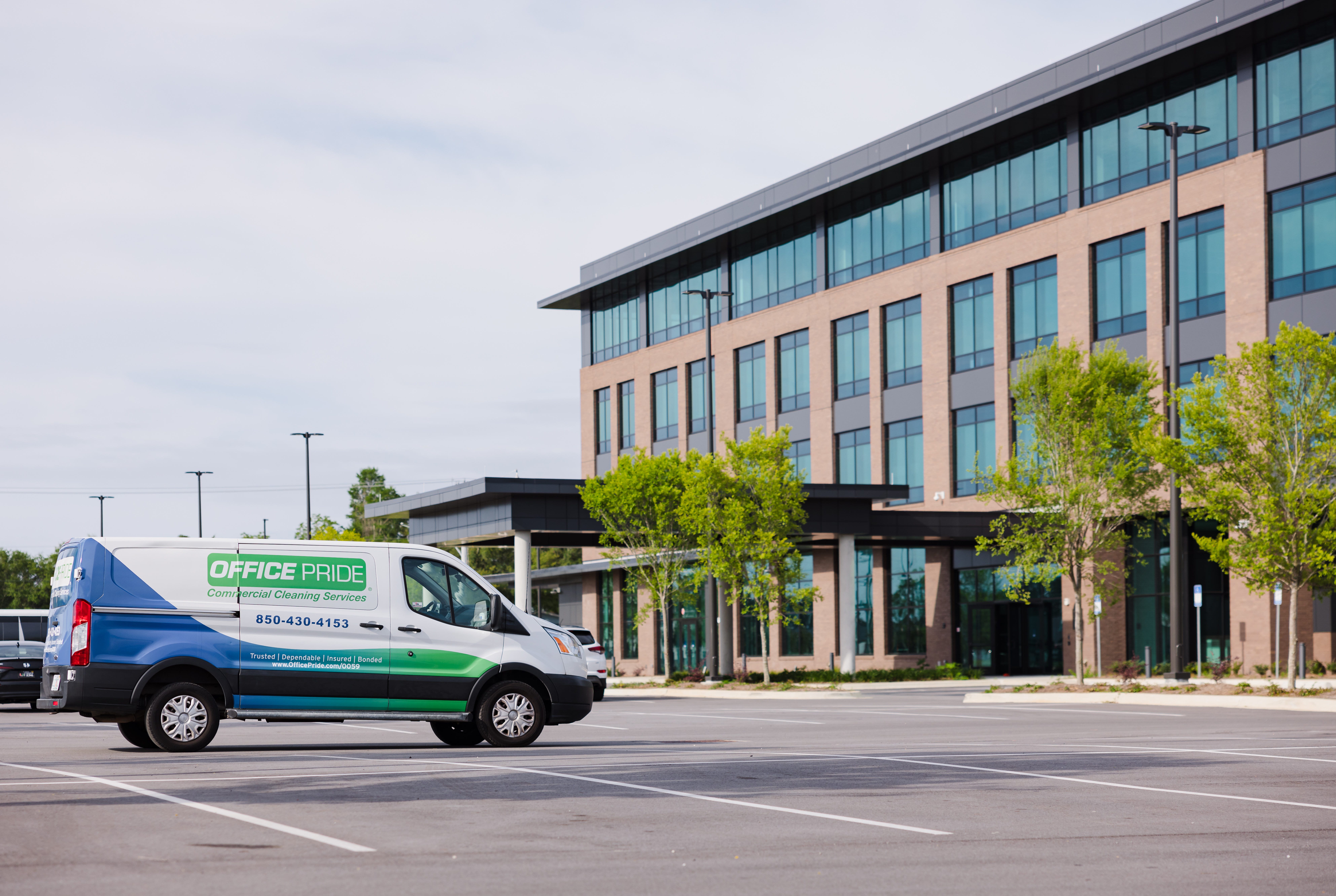 Office Pride commercial cleaning service vehicle outside a commercial facility