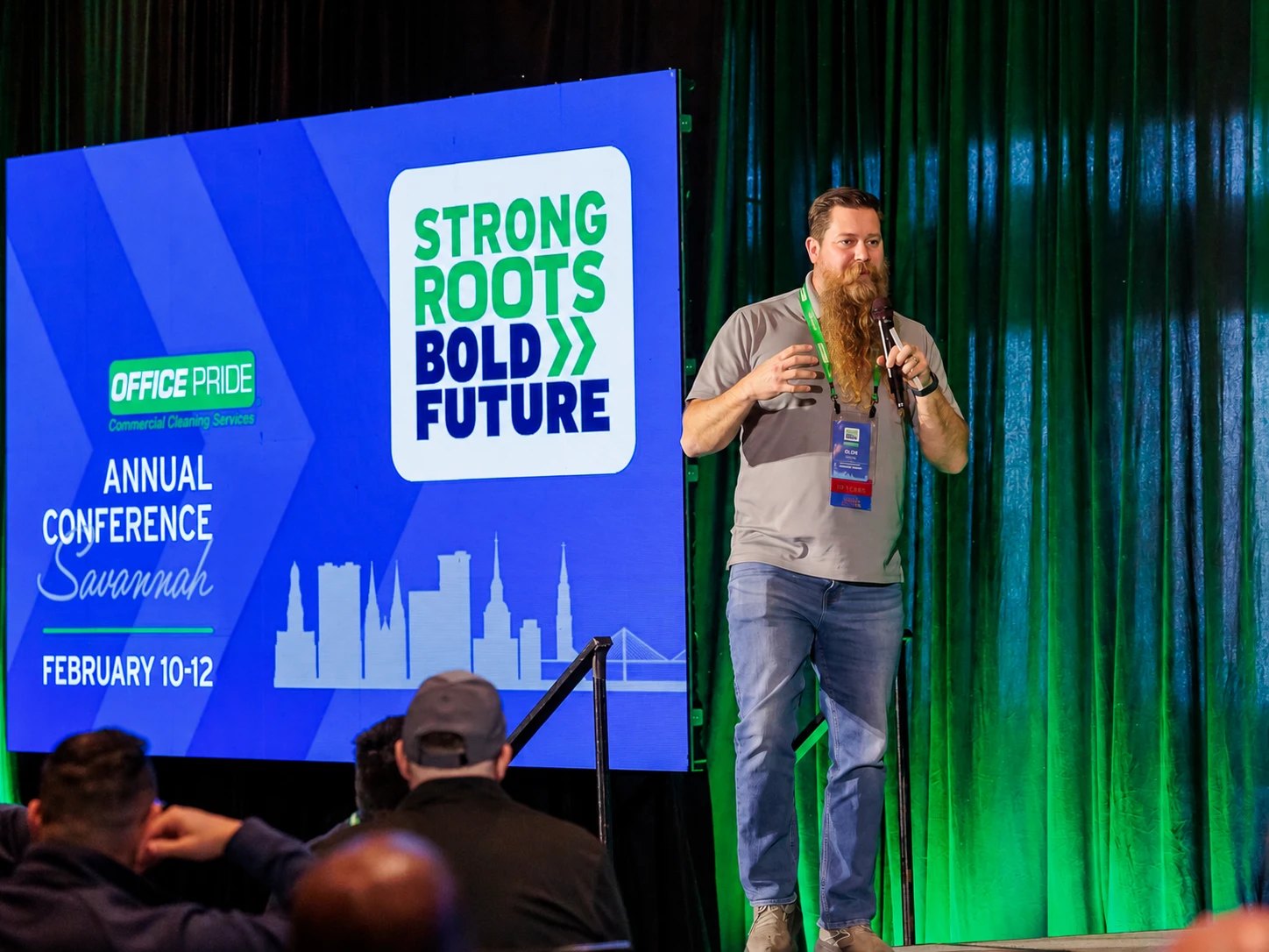 Office Pride franchise owner speaking on stage at the annual conference in Savannah